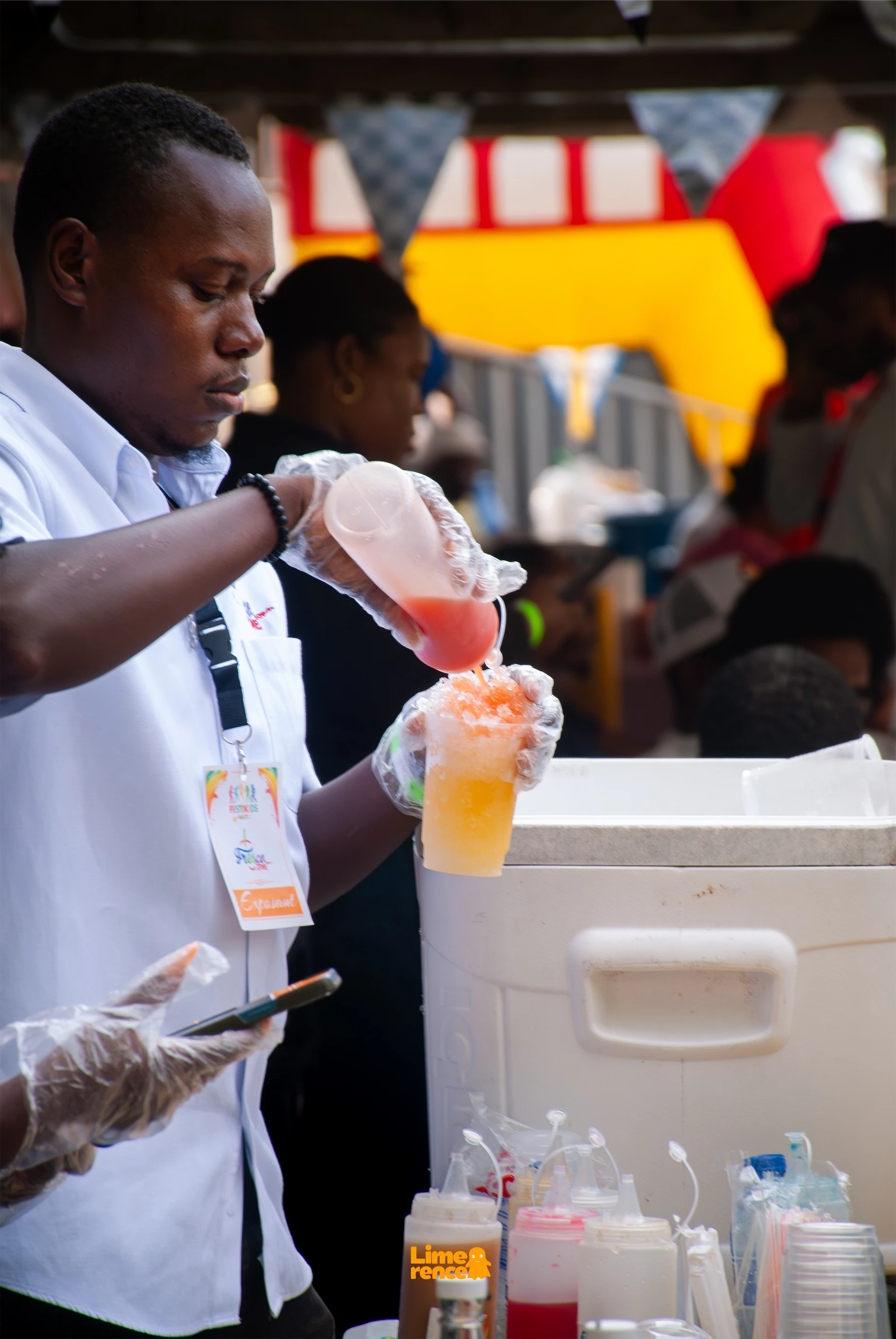 Exposant préparant une boisson colorée pendant FestiKids Haïti.